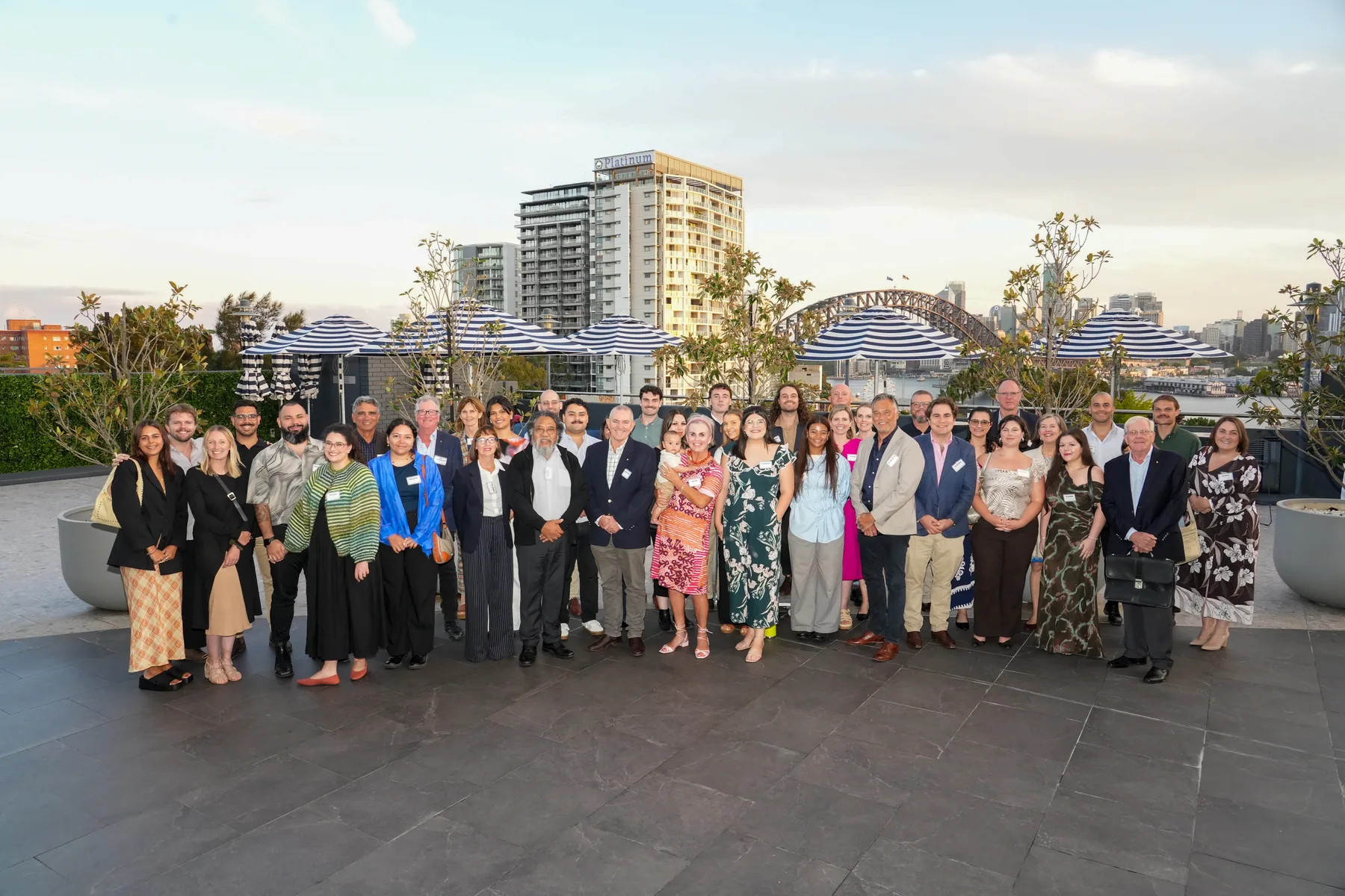 Guests at the 2026 Oakleigh Foundation Gathering on a North Sydney rooftop, with the Sydney Harbour Bridge behind them